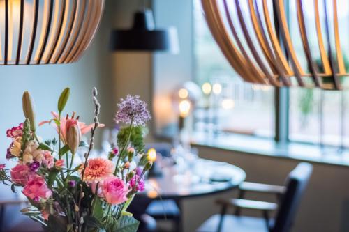a vase of flowers sitting on top of a table at LUDIEK eten en slapen in Havelte