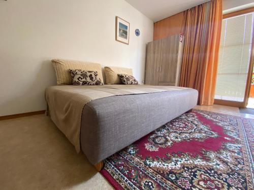 a bedroom with a bed with a rug and a window at Apartment Studio Van Bakel Gerard in Bled