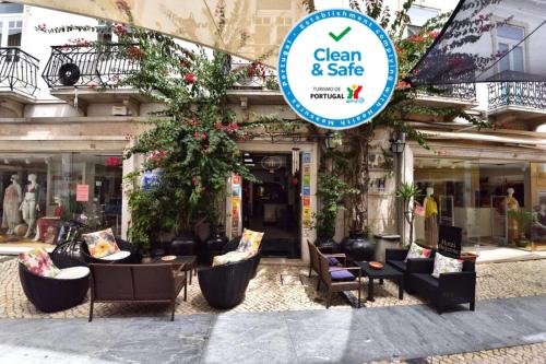 a store with chairs and tables in front of a building at Hotel Bejense in Beja