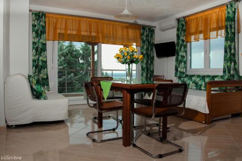 a dining room with a table and chairs and a bed at Luxury Apartment in Nikiti