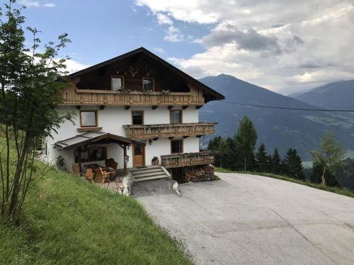 una casa sul fianco di una collina con una strada di Ferienhaus Berggrubenhof a Fügen