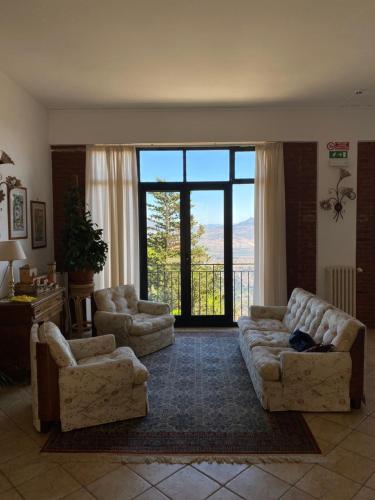 a living room with two couches and a large window at Hotel Villa San Giovanni in Erice