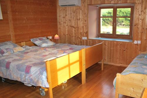 1 dormitorio con cama y ventana en La ferme du bonheur, en Pierrefontaine-les-Varans