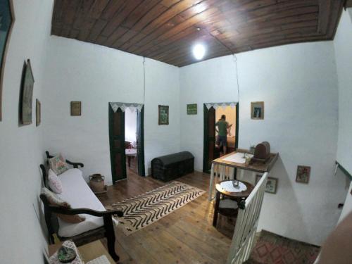 Um homem está numa sala com uma sala de estar. em Traditional GuestHouse Permet em Përmet