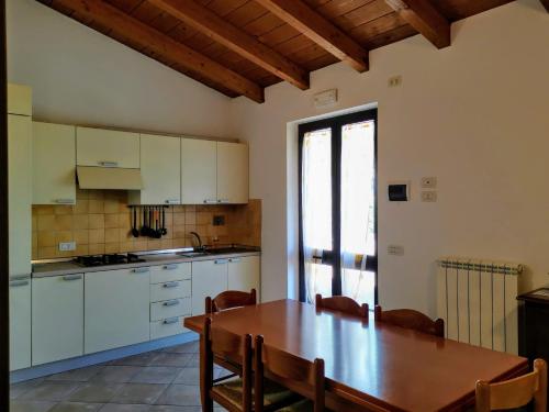 a kitchen with a wooden table and a dining room at Agriturismo Sole Luna in Piano Delle Pieve