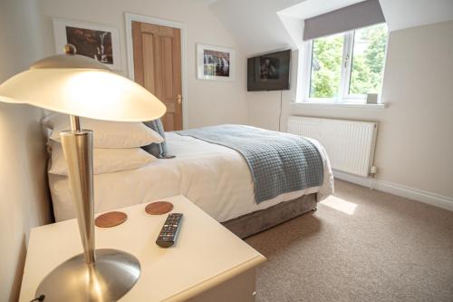 ein Schlafzimmer mit einem Bett und einer Lampe auf einem Tisch in der Unterkunft Mill Lodge-Brecon Beacons in Gilwern