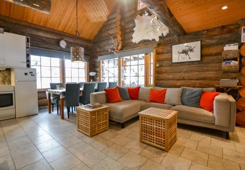 a living room with a couch and a table at Ylläshilla Cottage in Äkäslompolo