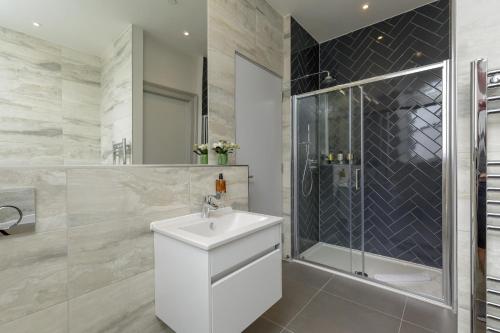 a bathroom with a white sink and a shower at Destiny Scotland - Princes Street Residence in Edinburgh