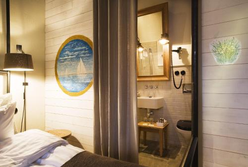 y baño con cama, lavabo y espejo. en Ulfsunda Slott, en Estocolmo