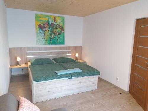 a bedroom with a bed with a green comforter at Penzion Loren in Františkovy Lázně