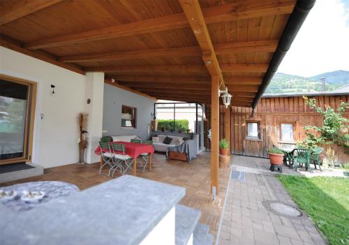 a patio with a table and chairs and a couch at Chalet Gloria - Doppel- und Mehrbettzimmer in Bruck an der Großglocknerstraße