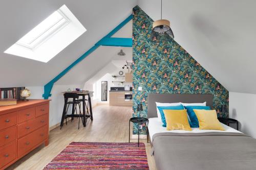 een slaapkamer met een bed met blauwe en gele kussens bij Le Cotissois in Lanvallay