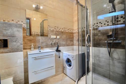 łazienka z pralką i prysznicem w obiekcie SŁONECZNE DOMKI w Istebnej