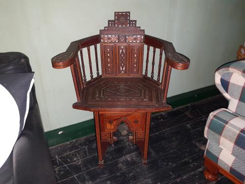 a wooden chair sitting in a corner next to a couch at UNIQUE 1920's Historic Retreat! Pet Friendly! in Springwood