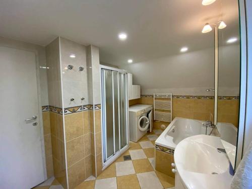 La salle de bains est pourvue d'une baignoire, d'un lavabo et d'une douche. dans l'établissement Apartment Kranj - huge terrace, free P, WI - FI, AC, à Kranj