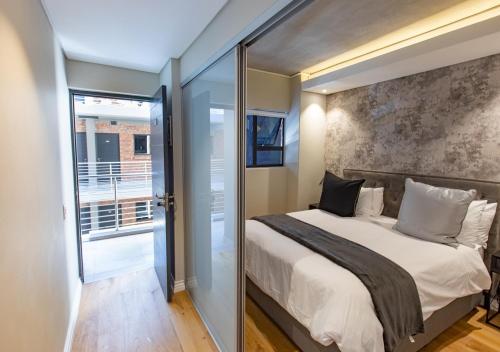 ケープタウンにあるDocklands Deluxe One Bedroom Apartments by ITC Hospitalityのベッドとガラスの引き戸のある寝室
