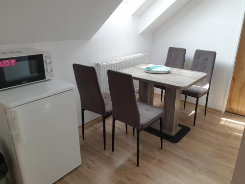 a dining room with a table and chairs and a microwave at Ubytování ADR100 Adršpach in Adršpach