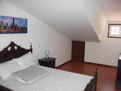 ein Schlafzimmer mit einem weißen Bett und einem Fenster in der Unterkunft vivendas Alves Pinho in Santa Maria da Feira