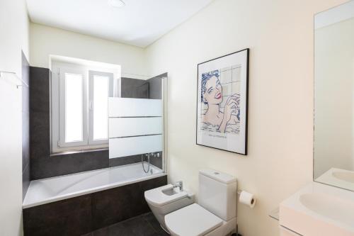 a bathroom with a white toilet and a sink at Ambassador Private Pool Suites in Lisbon