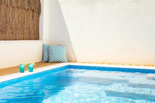 a swimming pool with two blue glasses sitting next to it at Ambassador Private Pool Suites in Lisbon