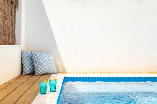 a swimming pool with two blue glasses next to it at Ambassador Private Pool Suites in Lisbon