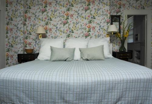 a bedroom with a large bed with floral wallpaper at 29 India House in Nantucket