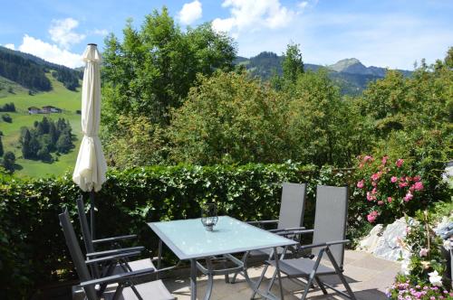 a table and chairs with an umbrella on a patio at Ferienwohnung am Sonnseitweg in Grossarl