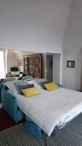 una camera con tre grandi letti con cuscini gialli di Dans village médiéval piétonnier, Suite exécutive vue mer exceptionnelle a Roquebrune-Cap-Martin