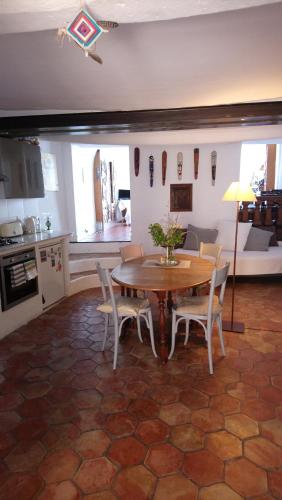 una cucina e una sala da pranzo con tavolo e sedie di Dans village médiéval piétonnier, Suite exécutive vue mer exceptionnelle a Roquebrune-Cap-Martin