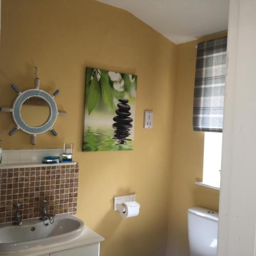 a bathroom with a sink and a mirror at Thyme Cottage in Whitby