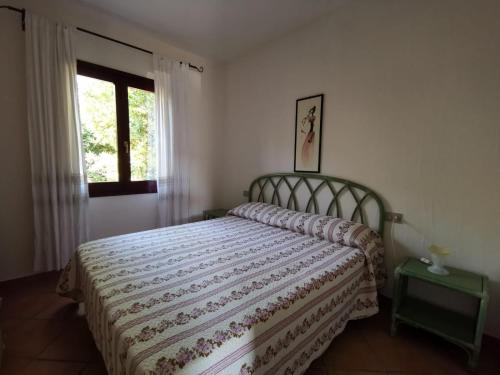 a bedroom with a bed and a window at Villetta Sterlizia in San Teodoro