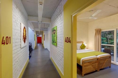 a room with a bed and a hallway at Bedzzz Rishikesh by Leisure Hotels in Rishīkesh