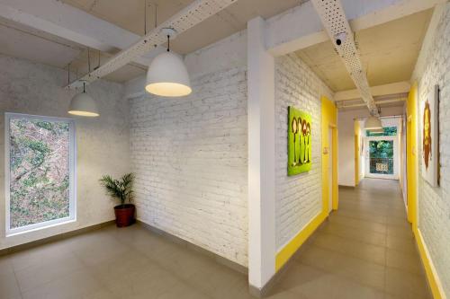 a hallway with a white brick wall and two lights at Bedzzz Rishikesh by Leisure Hotels in Rishīkesh