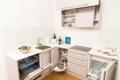 a kitchen with white cabinets and a dishwasher at Mint@Naschmarkt Premium Apartments in Vienna