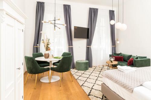 a living room with a table and green chairs at Mint@Naschmarkt Premium Apartments in Vienna