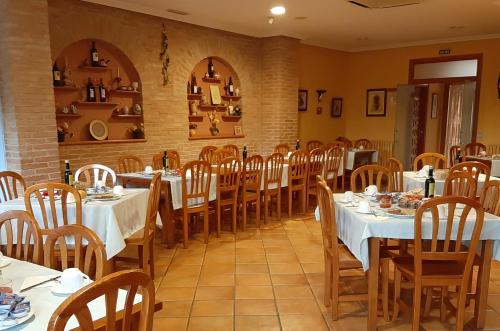 a dining room with white tables and chairs at Hostal Rural Casa Castro in Alberuela de la Liena