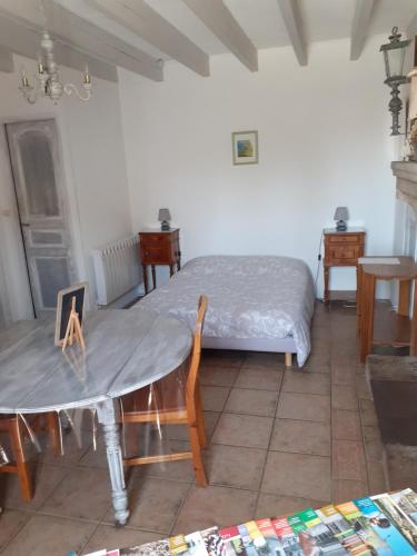 a room with a bed and a table and a bed at Chambre d'hôte du Plessis in Beaurepaire