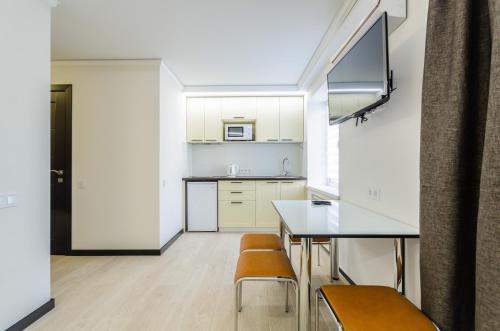 a kitchen with white cabinets and a table and chairs at ARTAL Apartment on Obolonskyi Avenue 31 in Kyiv
