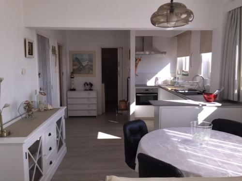a kitchen with a table and a dining room at Gezellig appartement voor het gezin in Middelkerke