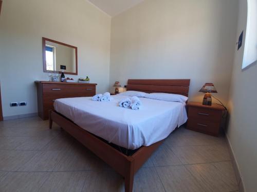 ein Schlafzimmer mit einem großen Bett und einem Spiegel in der Unterkunft Case Eoliane, Panarea in Patti