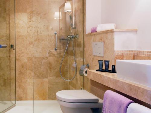 een badkamer met een douche, een toilet en een wastafel bij Hapimag Apartments La Madrague in La Madrague