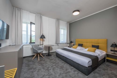 - une chambre avec un lit, un bureau et une chaise dans l'établissement Hotel Praha, à Špindlerův Mlýn
