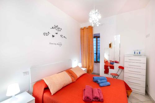 1 dormitorio con 1 cama naranja y 2 toallas en Al Pozzo Bianco, en Orvieto