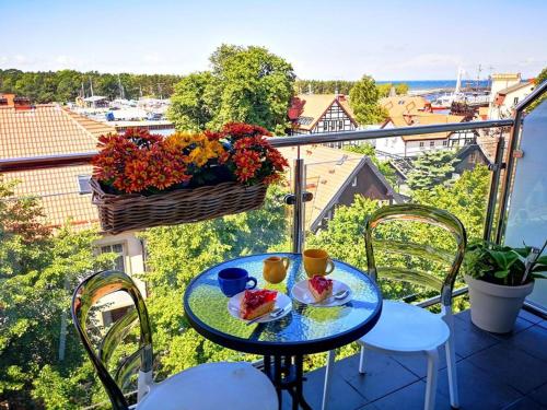une table avec deux assiettes de nourriture sur un balcon dans l'établissement Morski Apartament 2, à Ustka