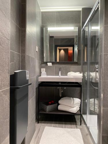 a bathroom with a sink and a mirror at Au Soleil, Hôtel Restaurant & Spa in Valff