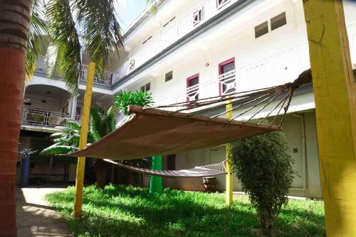 a hammock in the grass in front of a building at Hotel Victoria in Diego Suarez