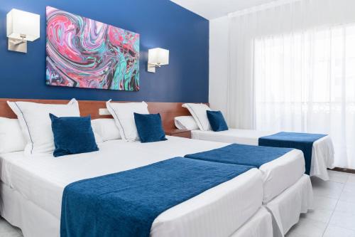 
a hotel room with two beds and a blue wall at Hotel Jaime I in Peniscola
