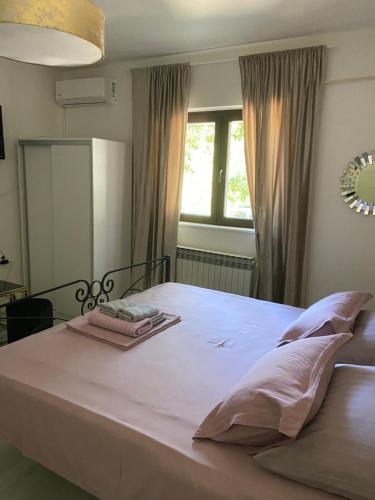 a bedroom with a large white bed with a window at Rooms Milena in Senj