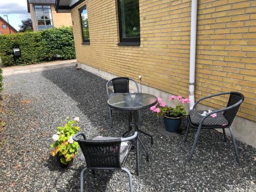a patio with two chairs and a table and some flowers at Shruti's Home in Billund
