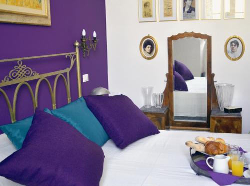 1 dormitorio con 1 cama con paredes de color púrpura y espejo en 900, en Livorno